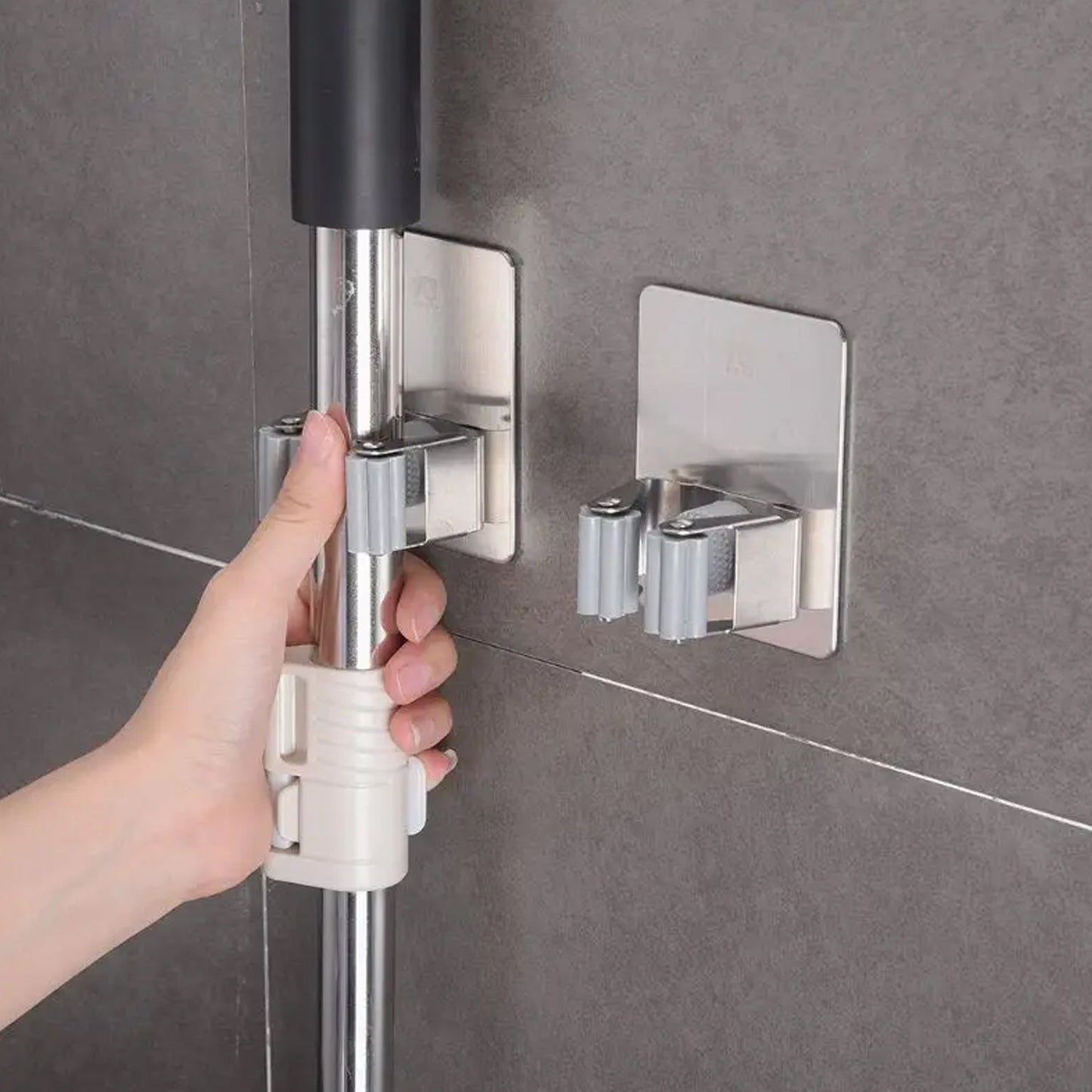 Stainless steel mop and broom holder, wall-mounted with adhesive glue.